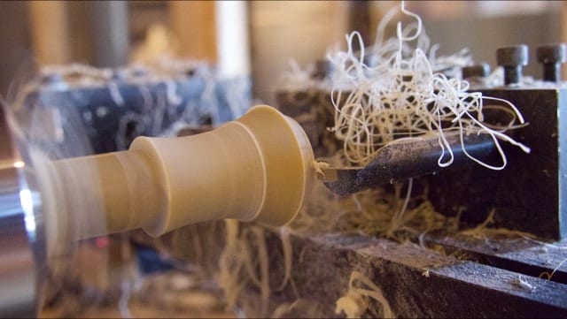 Craftsman turning a duck call on a lathe in the workshop